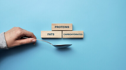 Wooden cubes with inscriptions: proteins, fats, carbohydrates. The balance of proteins, fats and...