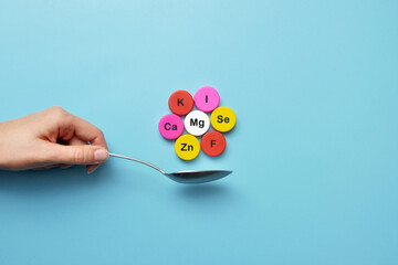 Icons of minerals and macronutrients on a spoon. The choice of food with a high content of vitamins and trace elements - obrazy, fototapety, plakaty
