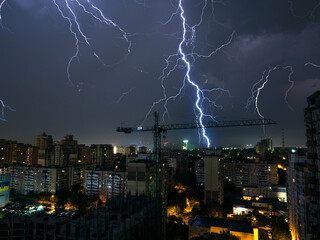 Dangerous thunderstorm with lightning in the night city.