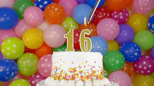 Birthday cake with candle numbers 16. Cake on a bright festive background of colorful balloons.