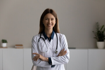 Head shot portrait smiling female doctor therapist with arms crossed, happy confident woman...