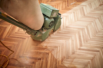 Restoring parquet with a sanding machine. © astrosystem