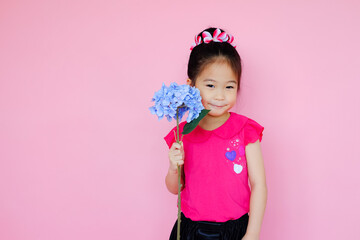 Little cute asia small girl on pink background with flower bouquet