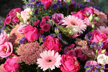 Trauerkranz mit vielen bunten Blumen auf dem Friedhof