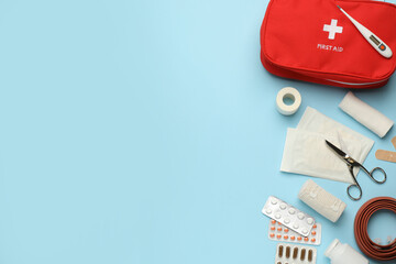 Flat lay composition with first aid kit on light blue background, space for text