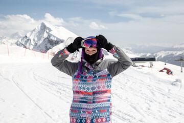 Fototapeta na wymiar Snowboarder girl putting on glasses