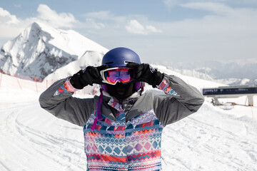 Fototapeta na wymiar Girl snowboarder straightens her goggles 