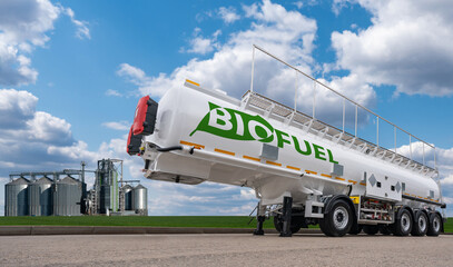 Tank trailer with the inscription BIO FUEL on the background of silos. Biofuel concept.