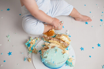 Little boy taste birthday cake with tiny fingers