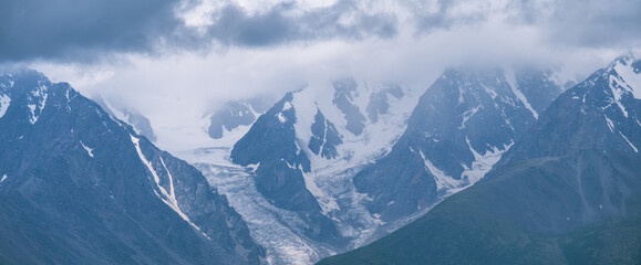 Fototapeta na wymiar Mountain peaks in the clouds, panoramic view