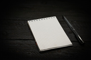 notebook and pen on black wooden background