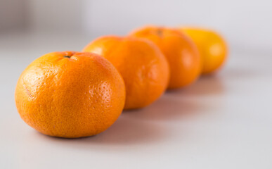 appetizing tangerines laid out in a row on white background