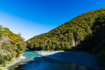 Fototapeta na wymiar ニュージーランド　オタゴ地方のブループールまでのウォーキングトラックからの風景と青く澄んだマカロア川