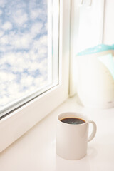 Fototapeta na wymiar cup of coffee on the window sill