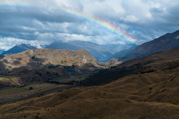 ニュージーランド　クイーンズタウン近郊のスキー場、コロネット・ピークの山上から望む景色と空に架かった虹