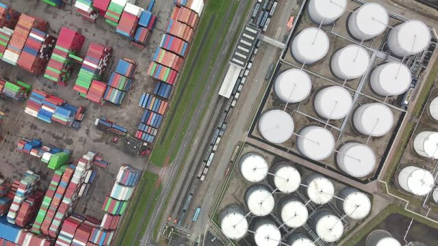 Container and silos in the Port of Rotterdam heavy industry and transportation along the Oude Maas Petroleum harbour aerial drone overview.
