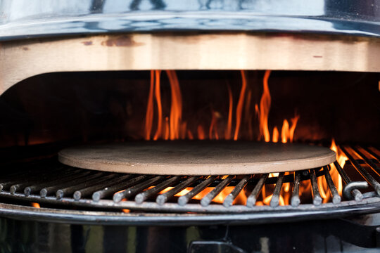 Pizzastein im Kugelgrill mit Feuer