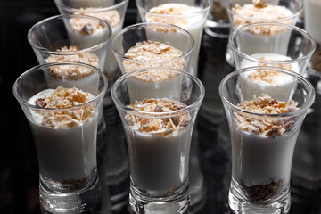 Creamy dessert of nuts in a glass stack on a dark background.