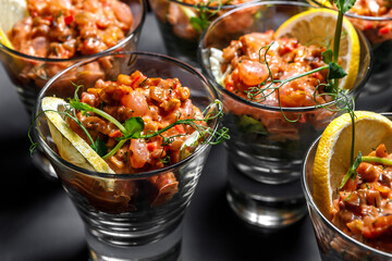 A light snack of shrimp, lemon and herbs in a glass stack.