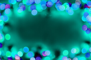 Defocused blue lights over dark background. Natural bokeh and bright blue lights. Magic background with bokeh. Space for text.
