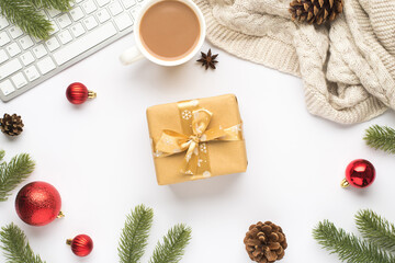 Top view photo of keyboard cup of hot drinking red christmas tree balls pine twigs cones anise scarf and giftbox with gold bow on isolated white background