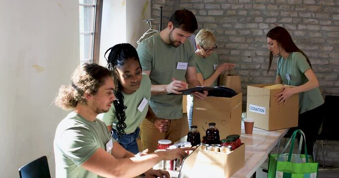 Group of volunteers working in community charity donation center.