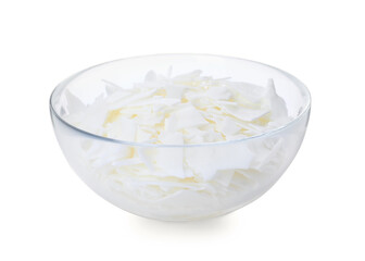 Wax flakes in glass bowl on white background. Homemade candle material