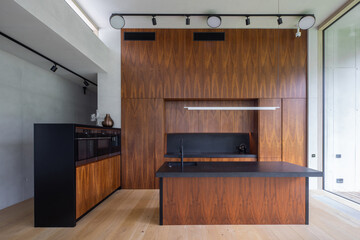 Interior of modern wooden kitchen with built-in appliances in house.