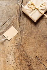 Weihnachtsgeschenk und Geschenkeanhänger auf rustikalem Eiche Holzbrett