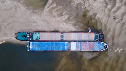 Two parallel tugships standed in sand river. Bird view perspective	