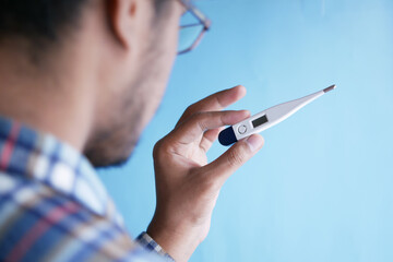 rear view of man hand hold a digital thermometer 