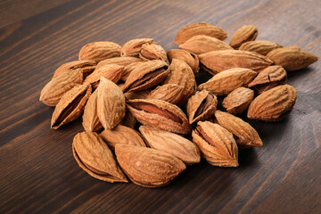 Almond nuts in a pile on a wooden texture background