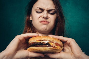 woman eating hamburger fast food snack close-up