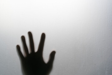 shadow human hand or people palm on window frosted glass or wall for near death help or murder assassin and dark ghost horror concept in toilet room on white light background to halloween with space