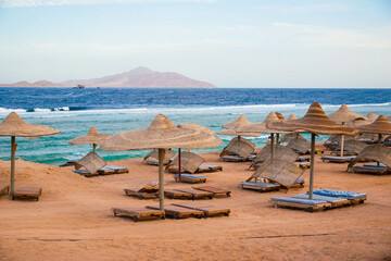 Sandy beach with deck chairs and parasols in low season