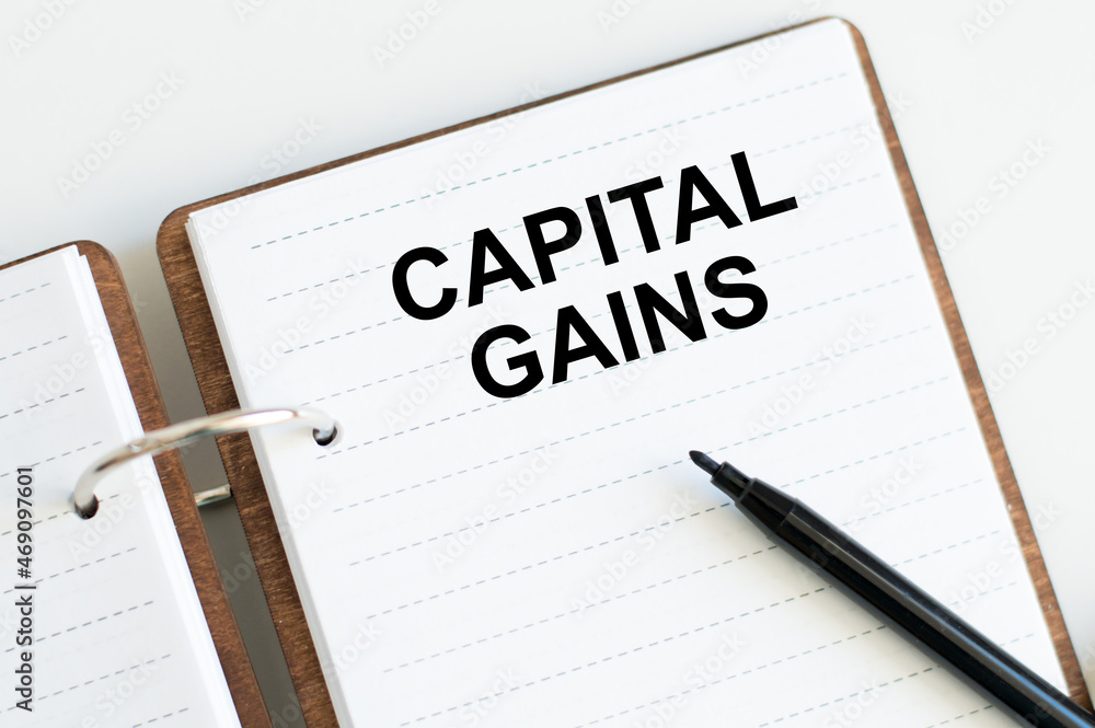 Poster notebook with text capital gains on the table. financial and concept photo