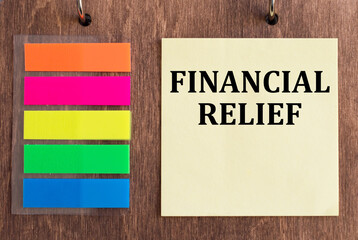 Text financial relief on yellow sticker on wooden background next to color stickers