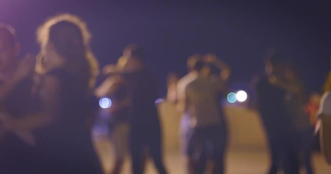 Dancing fiesta in a night.Many couples dance Latin-American social dances.Open-air music festival.Young people enjoy open-air salsa or samba dancing festival.Defocused couples dancing salsa in street