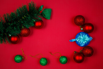 Christmas composition with decorations, fir tree branches on red background. Flat lay, top view, copy space. Minimalistic stylish background for design free space.