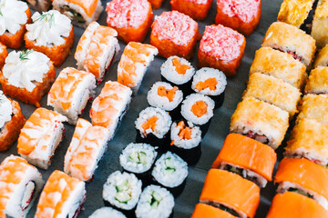 Different types of sushi rolls with salmon, shrimp, cheese and caviar.
