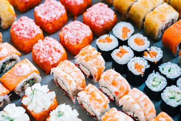 Different types of sushi rolls with salmon, shrimp, cheese and caviar.