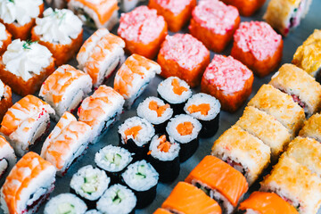 Different types of sushi rolls with salmon, shrimp, cheese and caviar.