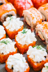 Different types of sushi rolls with salmon, shrimp, cheese and caviar.