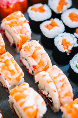 Different types of sushi rolls with salmon, shrimp, cheese and caviar.