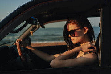 Fototapeta na wymiar woman on the beach is with a car wearing sunglasses travel