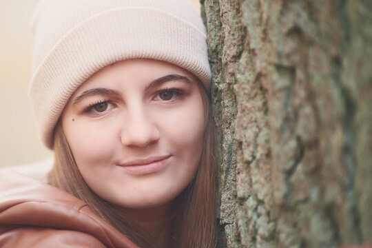 Portrait d'une belle adolescente avec un bonnet décontractée souriante regardant rêveusement 