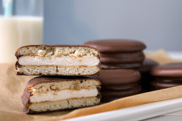 Tasty choco pies on parchment paper, closeup view