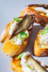Toast with cream cheese, sprats (sardine) and green onions. Simple homemade recipes concept.