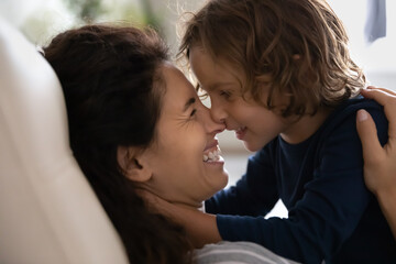 Close up hispanic happy mother and little son touching noses and looking in eyes, family enjoying...