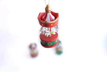 Wooden Christmas toy for the Christmas tree. Eco-friendly toy for Christmas. A small red, green and gold carousel in the form of a tent with white horses made of wood